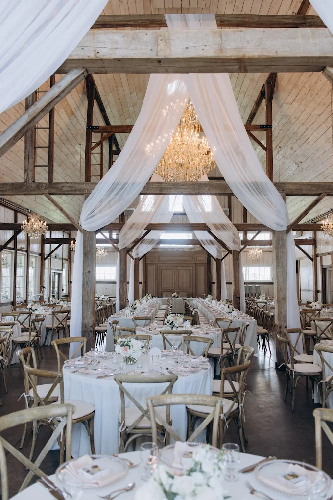White drapery and chandeliers above wedding reception tables at Stonefields